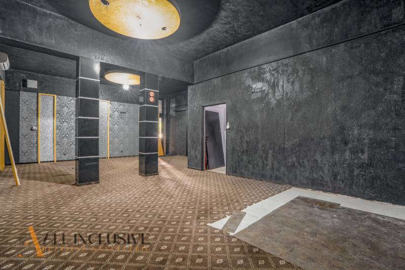 Dark commercial spaces with geometric patterns on the wall and ceiling.