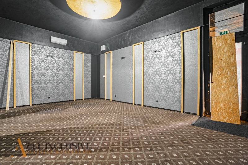 Commercial spaces with wallpaper and carpet, black ceiling, light, decorations.