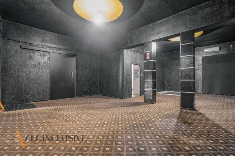 The interior of commercial spaces with dark walls and patterned carpet.