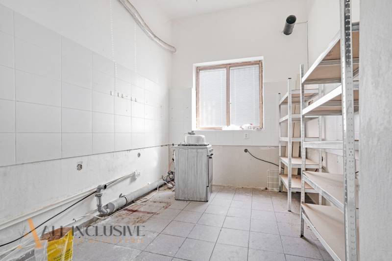 A space with washable walls, shelves, and neglected equipment in commercial premises.
