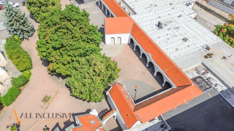 Aerial view of commercial premises with red roofs, greenery, and trees in Dunajská Streda.