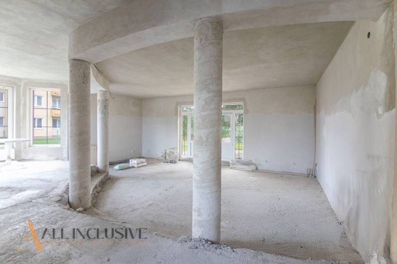 Interior of a family house with concrete columns and large windows.
