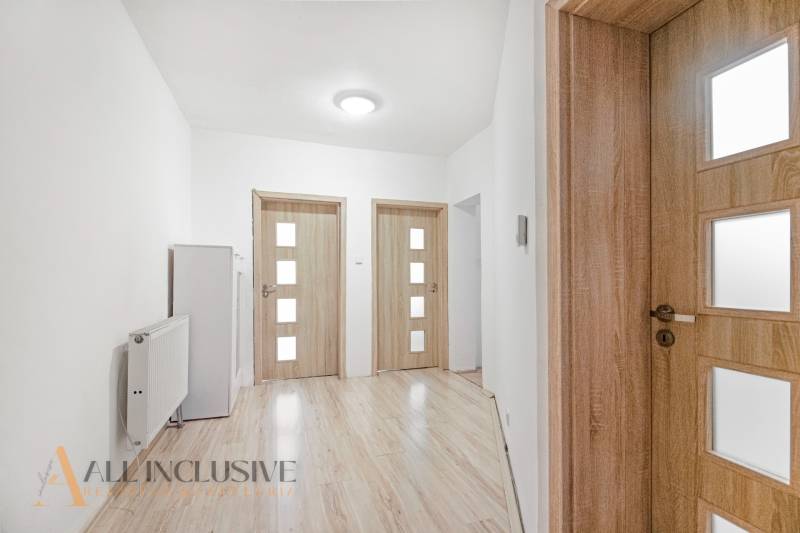 Interior of a family house with wooden doors, laminate flooring, and white walls.