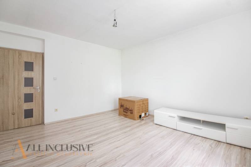Living room in a family house with wooden doors and white furniture.