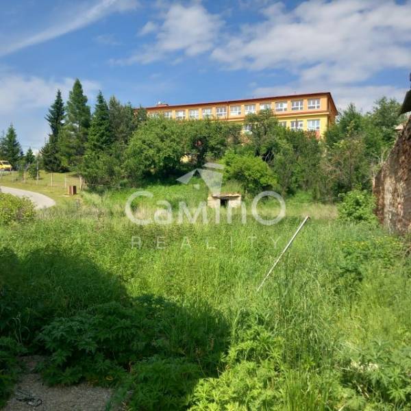 Greenery and building in the background in Pozemky - bývanie, Ľubotín. Serene environment for living.