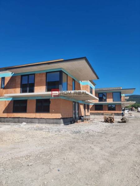 A new building with modern architecture under construction in Dubová, surrounded by spacious natural surroundings.