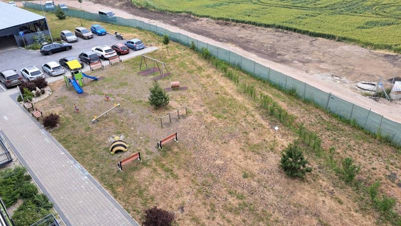 Parking lot and children's playground next to the residential building on Suchoňova Street in Poprad.