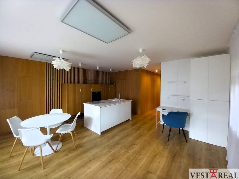 A kitchen in a family house with wooden floors and white furniture.