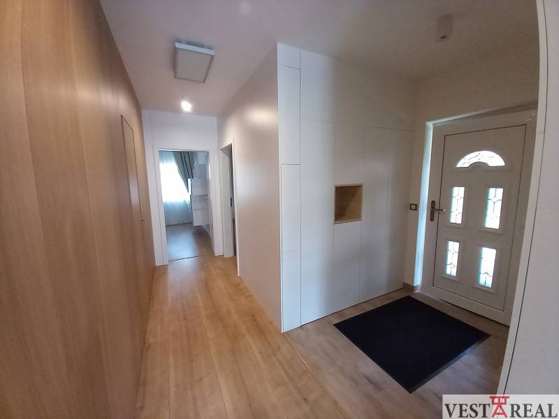 Entrance hall in a family house with wooden flooring and white walls.