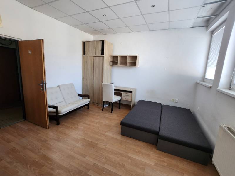 Interior of a building with furniture: sofa, bed, wardrobe, and desk.