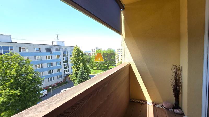 A loggia in a 2-room apartment in Zvolen offering a view of the surroundings and trees.