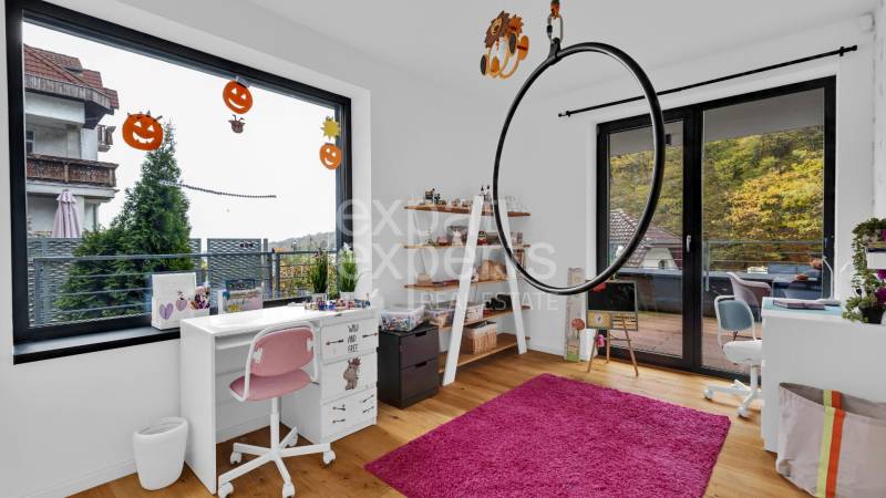 A children's room in a family house with white furniture, a pink carpet, and Halloween decorations.
