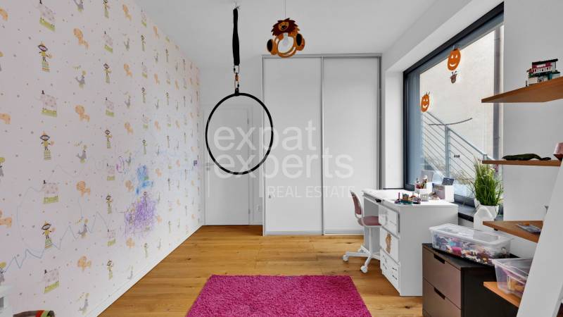 Children's room in a family house with a swing, a desk, and shelves for toys.