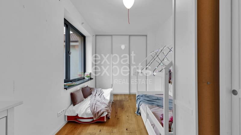 Children's bedroom with a bunk bed and a large window in a family house.