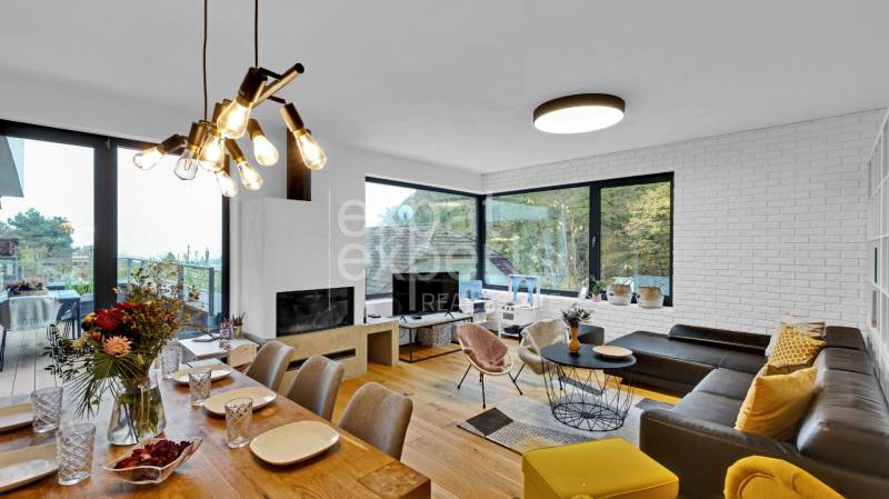Living room of a family house with a dining table, large windows, and comfortable seating.