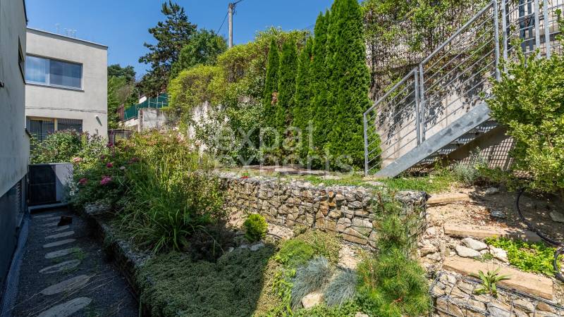 A garden with stone walls and a staircase at a family house on Sliačska Street in Bratislava.