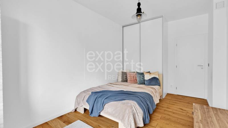 A bedroom with a single bed, wooden floor, and a combination of muted colors in a family house.