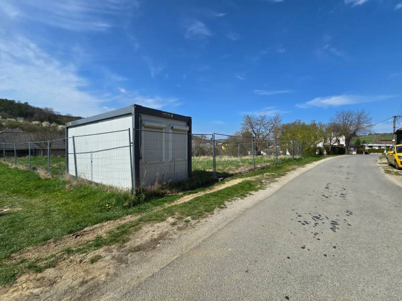 A container on the street, surrounded by plots suitable for living, with a side road to Krajné.