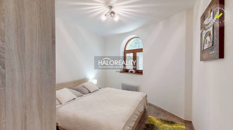 Bright bedroom with a double bed, wooden window, and a painting in a 3-room apartment.