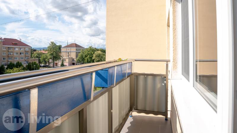 A balcony with a view of the surrounding houses and greenery in Nova Dubnica, 2-room apartment.