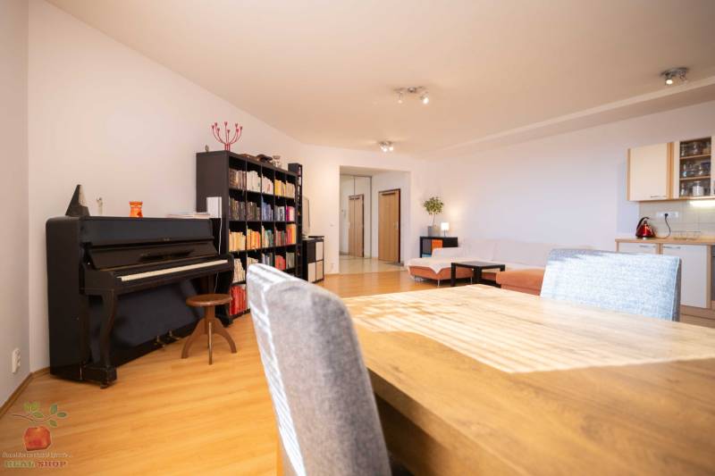Living room with a piano, bookshelf, and corner sofa in a 3-room apartment.