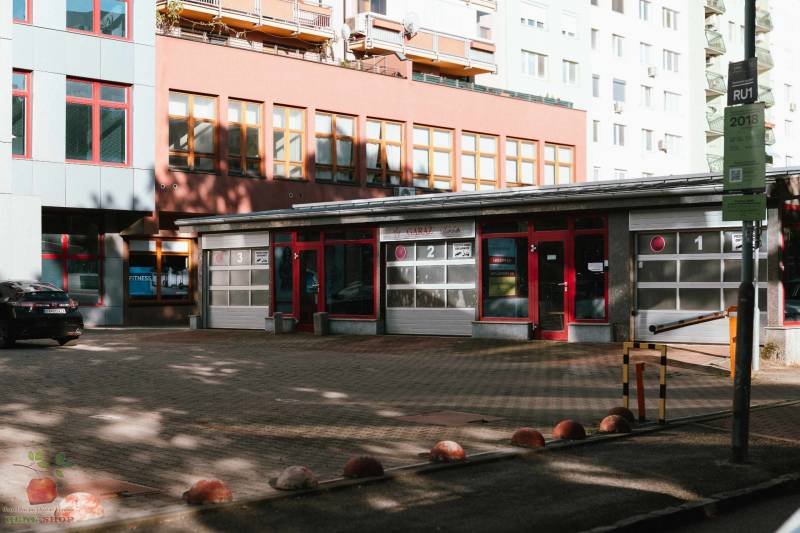 The building on Záhradnícka Street in Bratislava with garage doors and an adjacent parking lot.