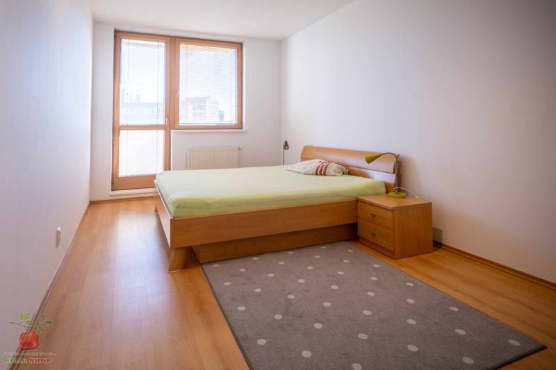 Bedroom in a 3-room apartment with a bed, window, and wooden floor.