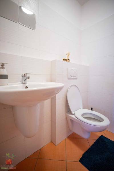 Bathroom in a 3-room apartment with a sink, toilet, and tiles in light colors.