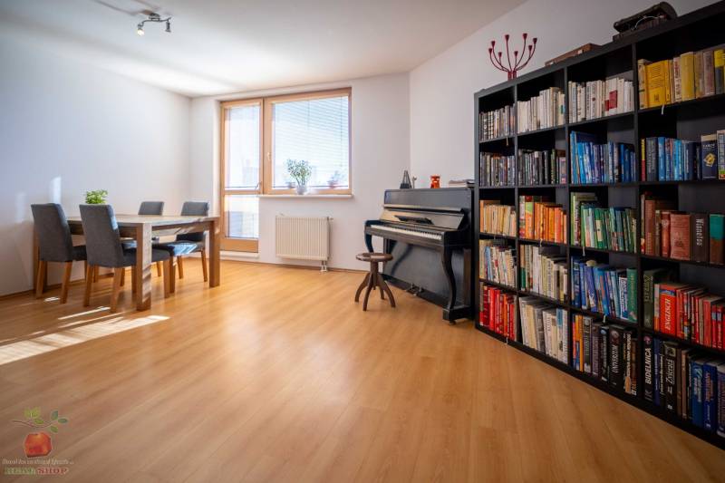 Living room with a piano, bookshelf, table, and chairs in a 3-room apartment.