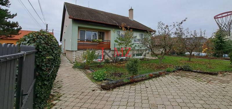 A family house in Levice with a landscaped garden and a paved access road.