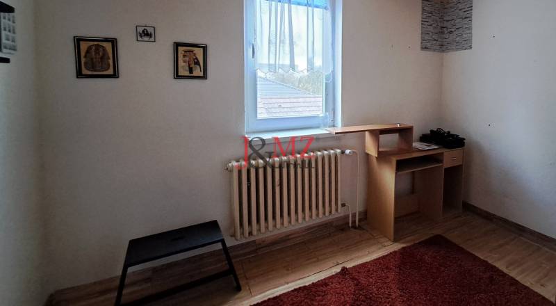 A room in a family house with a wooden floor, carpet, and furniture.