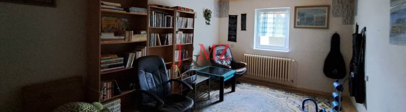 Living room in a family house with a library, armchairs, and a table.