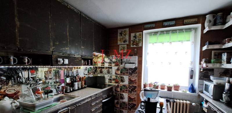 A kitchen in a family house with hanging shelves, kitchen tools, and decorative glasses.