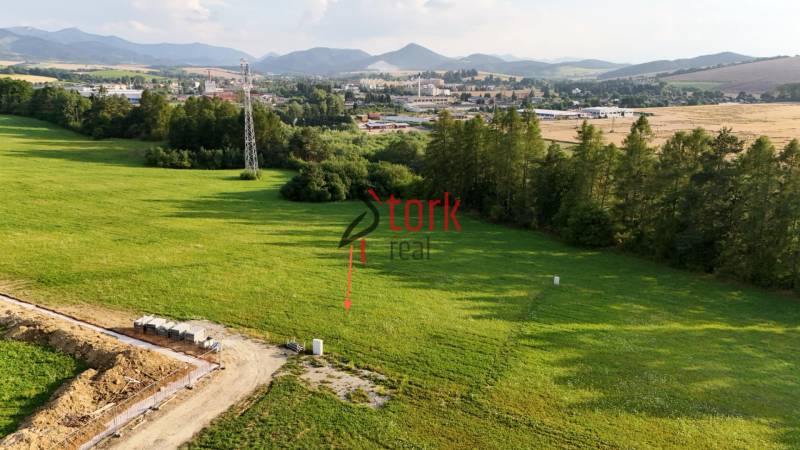 Panoramic view of residential building plots in Kľače with visible power pylons.