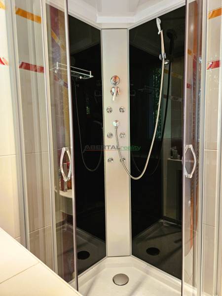Shower enclosure with glass doors in a 2-room apartment.
