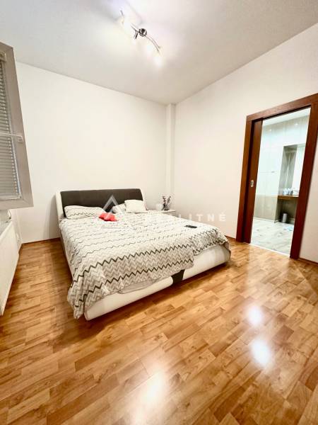 A bedroom with a bed and wooden floor in a 2-room apartment.