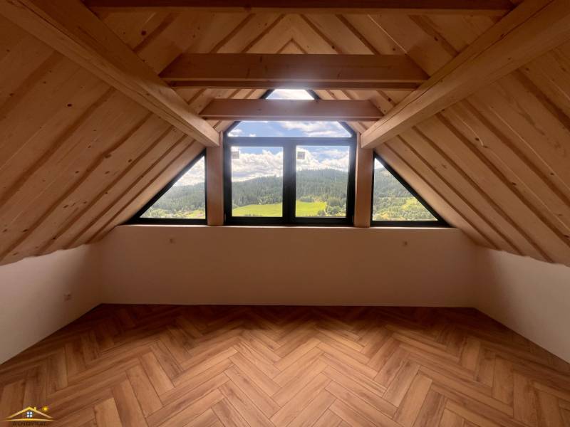 Attic space in a cabin with mountain views and wooden beams.