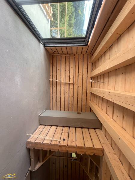 A wooden interior in a cabin with a view of nature through a large window.