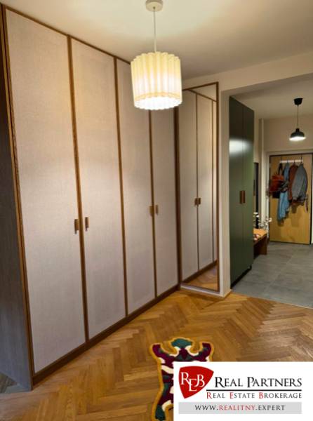 Entrance hall with a built-in wardrobe and mirror in a 4-room apartment.