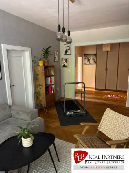 Living room with light furniture, plants, decorations, and a treadmill in a 4-room apartment.