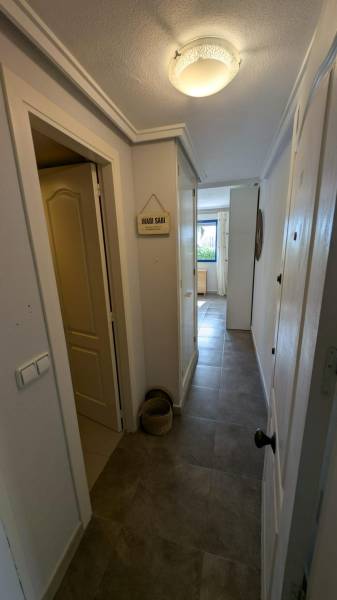 A narrow hallway in a studio apartment with bright lighting and wall decorations.