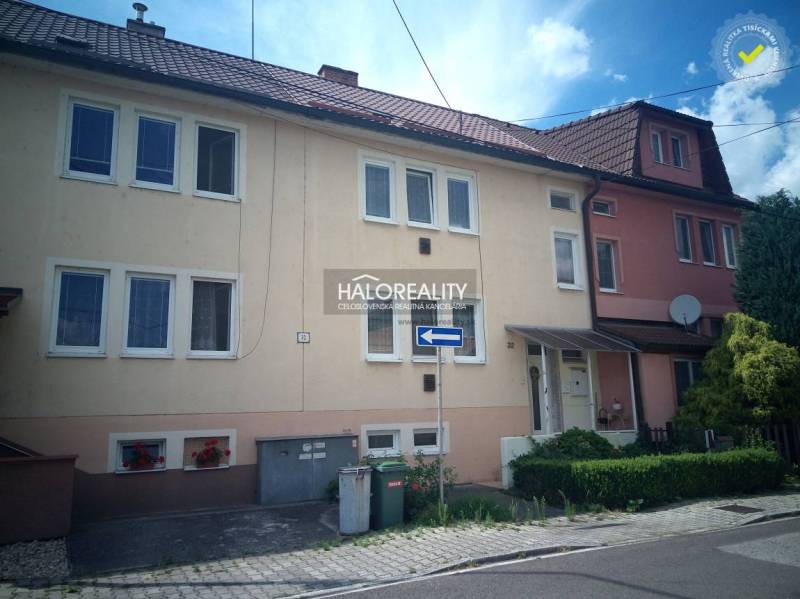 A family house in Nováky with a garage and floral decorations on the facade.