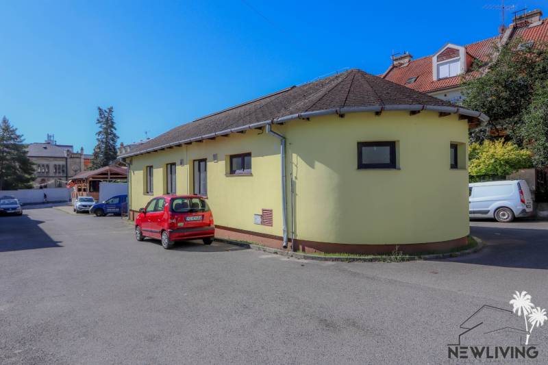 The yellow building on Slovenského národného povstania Street in the town of Vrbové with a parked red car.