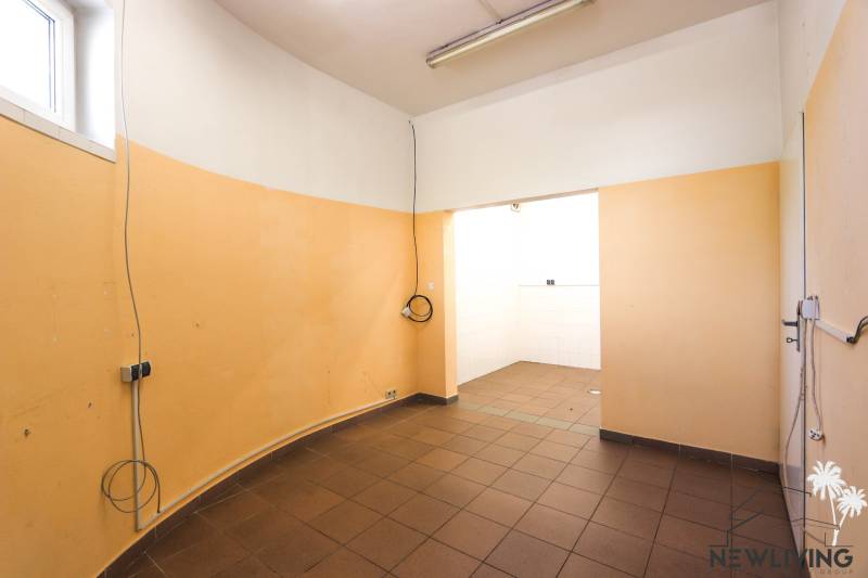 Interior of commercial premises with orange walls and brown flooring.