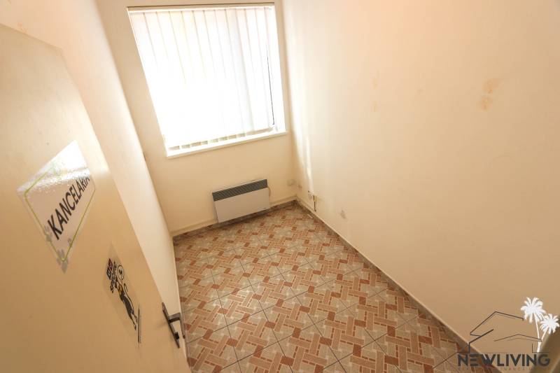 Small room with tiles, radiator, and sign 