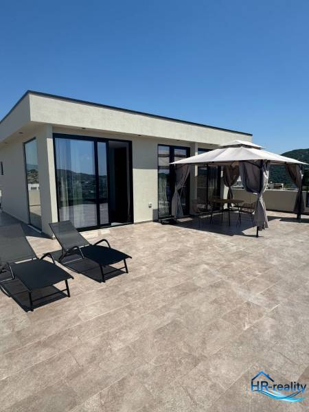 A recreational apartment in Ksamil with a terrace, sunbeds, and a garden gazebo for relaxation.