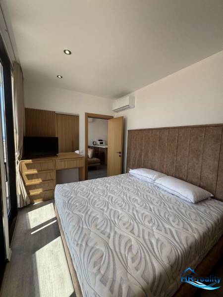 Bedroom in a holiday apartment with a double bed, built-in wardrobe, and air conditioning.