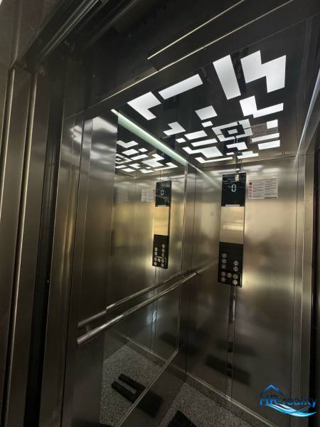 Interior of an elevator with modern lighting and mirrors in a Recreational Apartment.