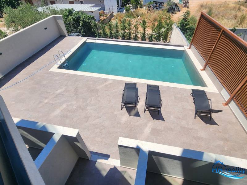 A holiday apartment in Ksamil with a pool and sun loungers on the sun terrace.