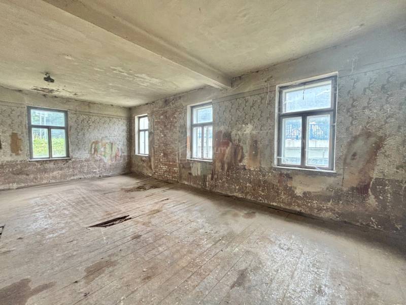 Abandoned room in a family house with damaged floors and walls.